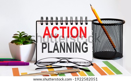Notebook with Tools and Notes with text ACTION PLANNING , business