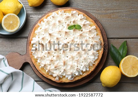Flat lay composition with delicious lemon meringue pie on wooden table