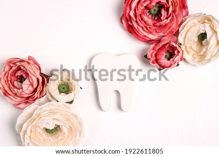 Festive dental background with tooth surrounded by pink and white peonies on a white background with copy space for text. Happy Dentist's Day concept .