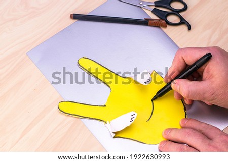 making the simplest Easter bunny with your own hands a person draws a rabbit's eyes nose and mouth. High quality photo