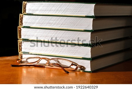Glasses and a stack of books on the table