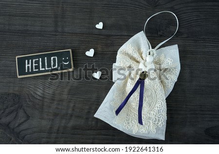  angel with delicate lace, hearts and a sign with the inscription hello on a wooden background                              
