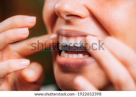 Woman Using Whitening Stipes or Whitestrips. Whitening Teeth at Home.  Royalty-Free Stock Photo #1922652398