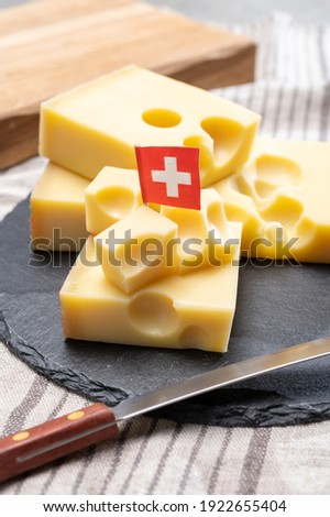 Block of Swiss medium-hard yellow cheese emmental or emmentaler with round holes and cheese knife close up Royalty-Free Stock Photo #1922655404
