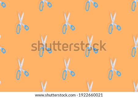 Scissors seamless pattern. Barber scissors on an orange background. 