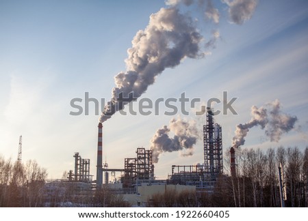 Petrochemical industrial factory of heavy industry, power refinery production with smoke pollution. Thick smoke is coming from the factory's chimney Royalty-Free Stock Photo #1922660405
