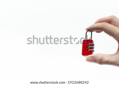 Small Red Lock In Hand on White Background. Hand holding small combination lock. Security Concept.