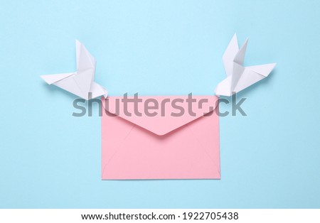 Origami carrier pigeons with envelope on a blue background