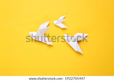 Origami paper doves on a yellow background. Peace symbol Royalty-Free Stock Photo #1922705447
