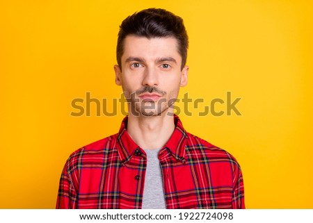 Photo of serious confident young man wear red checkered shirt isolated yellow color background