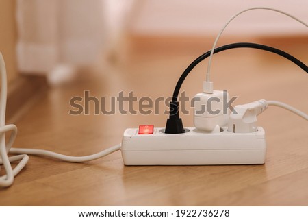 White cable connector for overloaded power boards at home. Close up focus at a plug foreground. Royalty-Free Stock Photo #1922736278