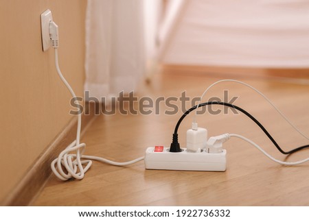 White cable connector for overloaded power boards at home. Close up focus at a plug foreground. Royalty-Free Stock Photo #1922736332