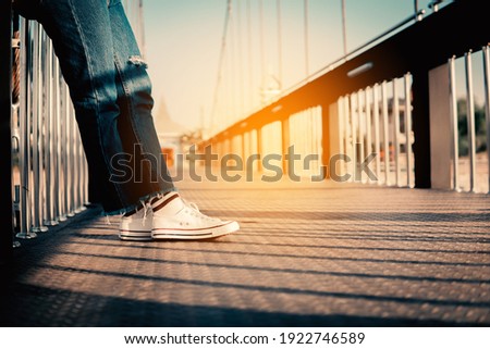 hipster tourist traveler feet on bridge background, resting lifestyle on vacation.