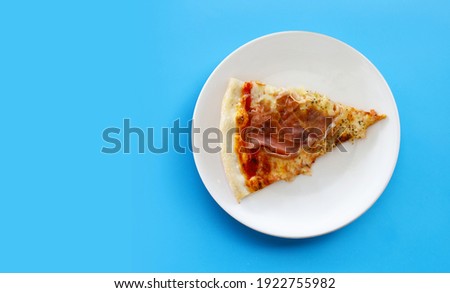 Pices of Pizza on white plat on blue background. Royalty-Free Stock Photo #1922755982