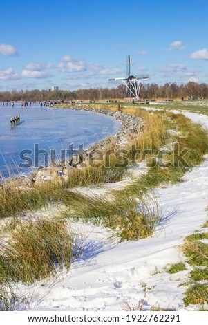 Historic windmill at the frozen lake in Paterswolde, Netherlands