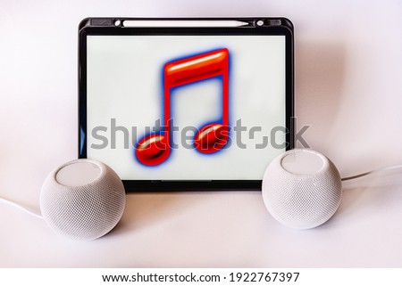 View of tablet computer with note drawing and two smart speakers. Listen to music in stereo mode