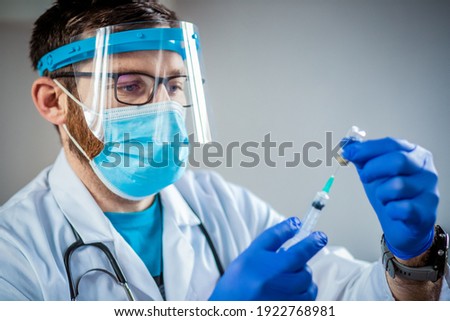 male doctor preparing to give coronavirus vaccine