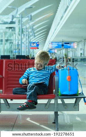 little boy with touch pad waiting in the airport