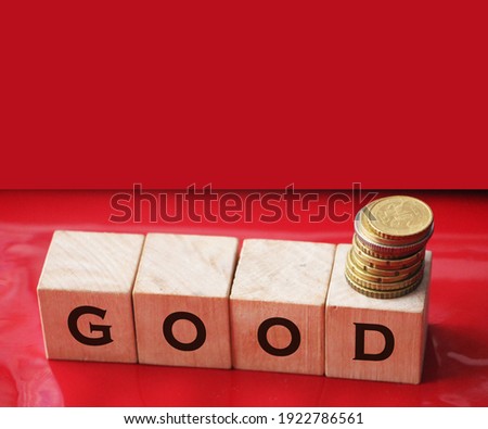 Text goodness on wood cube block, stock investment concept. The text goodness is written on the cubes in black letters, the cubes are located on a blue glass surface.