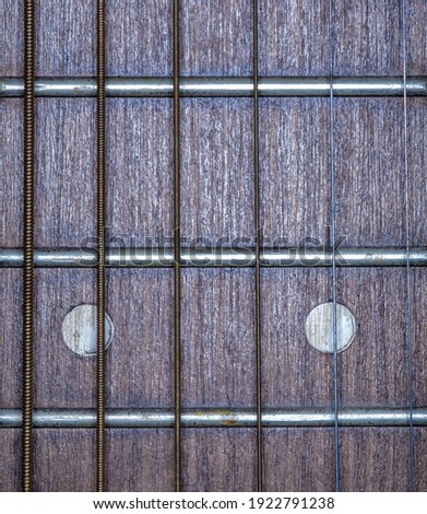 Metal strings of a six-string acoustic guitar.