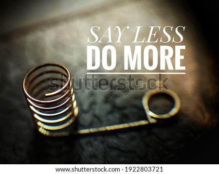 'Say Less, Do More' motivation quote with a spring in blurry background.