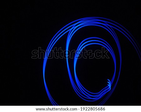 Spiral blue line light isolated on black background. Bright, LED, electrical, neon, technology.

