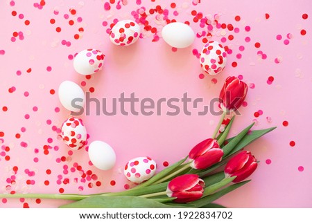 Happy Easter. Easter eggs decorated with paper confetti and tulips