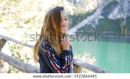 Pretty young girl with long hair smiling laughing candid photo outdoors in nature alpine area tourist enjoying real emotion cheerful uplifting inspiring female authentic portrait caucasian confidence 