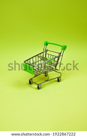 Metal mini shopping trolley isolated on a pistachio-green background with copy space, shopping symbol. Sales concept . High quality photo