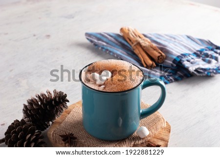 Blue mug with hot cocoa drink and mash mellows laid on vintage table Royalty-Free Stock Photo #1922881229
