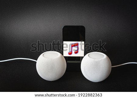 View of mobile phone with note drawing and two smart speakers. Listen to music in stereo mode. Music streaming on mobile devices.