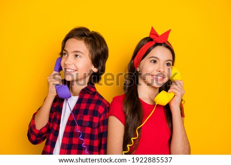 Portrait of cheerful kids hand hold vintage handset receive call speak isolated on yellow color background
