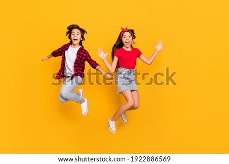 Full size portrait of two excited persons enjoy jumping open mouth isolated on yellow color background Royalty-Free Stock Photo #1922886569