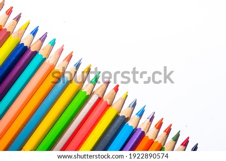 partial view of row of color pencils diagonally on white background
