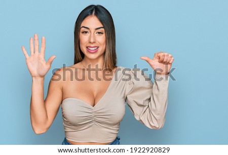 Young hispanic woman wearing casual clothes showing and pointing up with fingers number six while smiling confident and happy. 