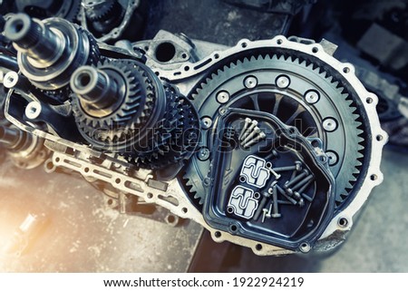 Closeup disassembled car automatic transmission gear part on workbench at garage or repair factory station for fix service or maintenance. Vehicle part detail. Complex industrial mechanism background Royalty-Free Stock Photo #1922924219
