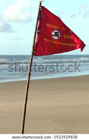 Red flag at the beach warning about strong currents in the area