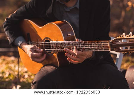 A male musician plays an acoustic guitar at a wedding for live music  Royalty-Free Stock Photo #1922936030