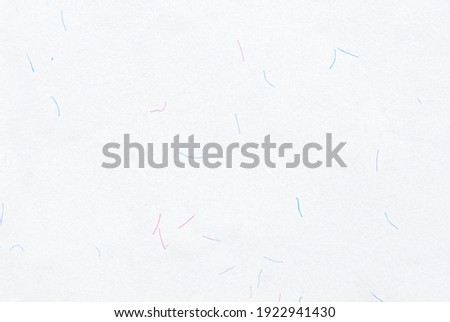 White watermarked paper with colored fibers particles