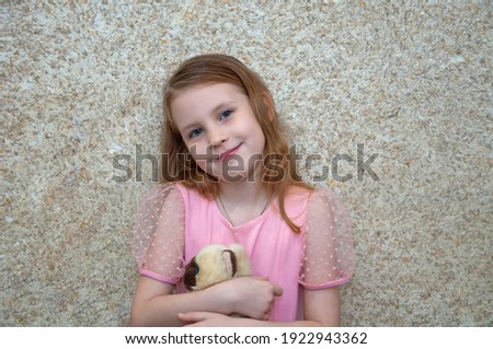 Girl with a soft toy rejoices and laughs.