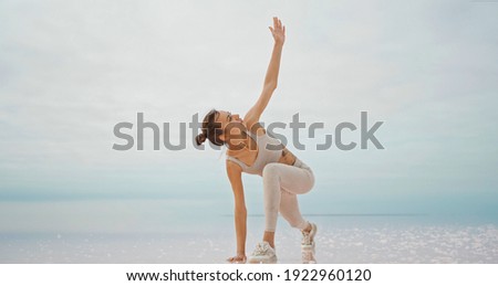 Active confident woman doing yoga in fresh air. practices yoga in salt lake desert. Concept of healthy lifestyle.