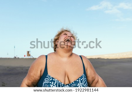 Happy plus size woman laughing on the beach - Curvy overweight model having fun during vacation in tropical destination - Over size confident person concept