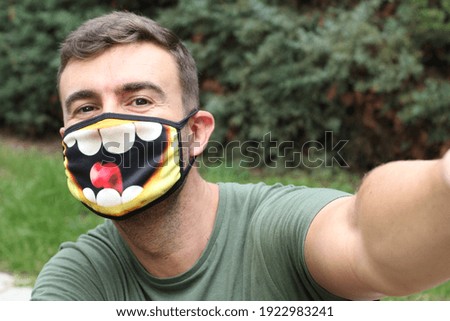 Humorous man wearing optimistic protective mask
