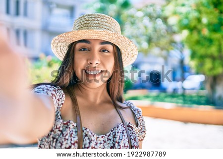Young latin woman on vacation smiling happy making selfie by the camera at street of city.