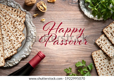 Top view of pesach background. Passover celebration with wine and matzah on the wooden background. With Happy Passover lettering. Royalty-Free Stock Photo #1922995070