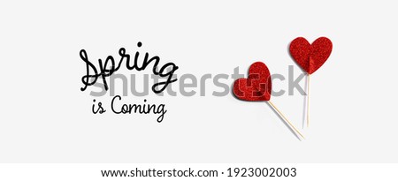 Spring is coming message with red glitter heart picks - flat lay