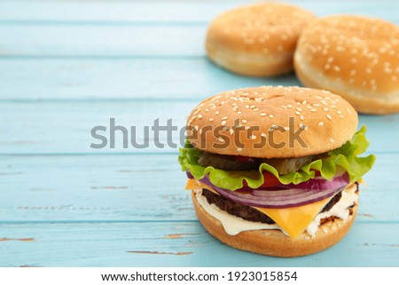 Homemade burger ingredients arranged on blue wooden background. Top view