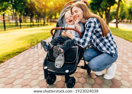 Young beautiful mother, with her little cute child, walking in the park on a sunny summer day. Royalty-Free Stock Photo #1923024038