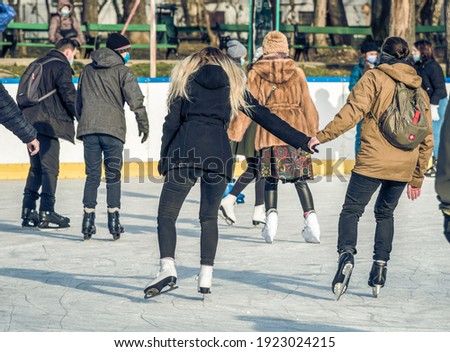 Rear view with people enjoying ice skating on the Cismigiu ice rink, in Bucharest.