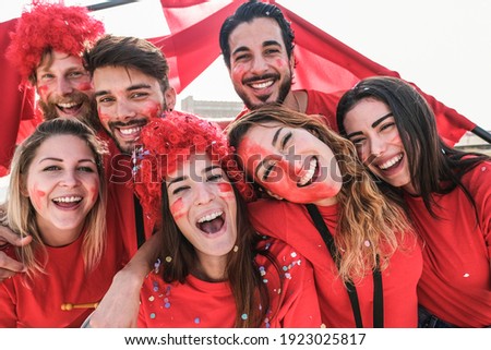 Crazy football fans having fun outside stadium for soccer match - Focus on center girls faces Royalty-Free Stock Photo #1923025817